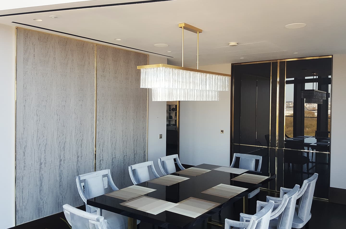 Dining room view of Westminster bespoke panelled doors with polished brass lines
