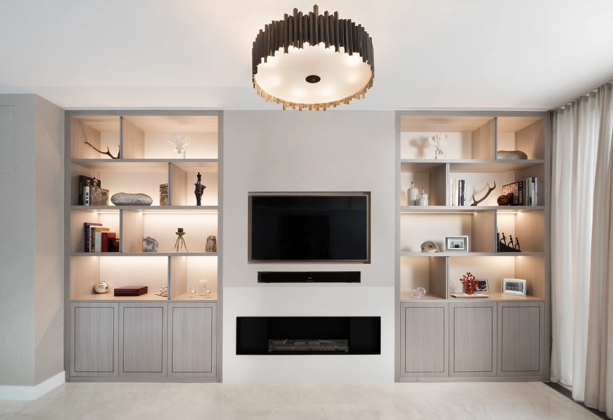 Full view of both pale Fulham alcove units around the television and fireplace