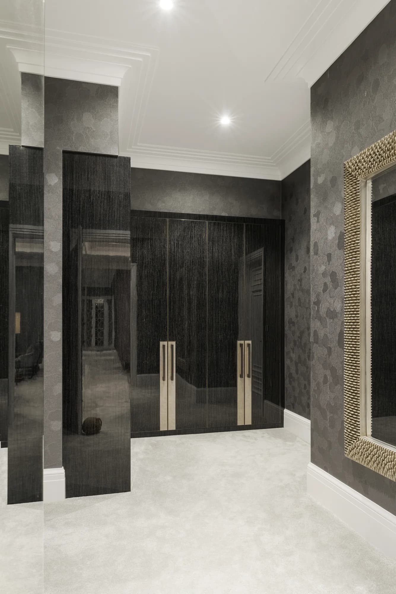 Overall view of the dark fitted walk-in wardrobe at the Esher residence