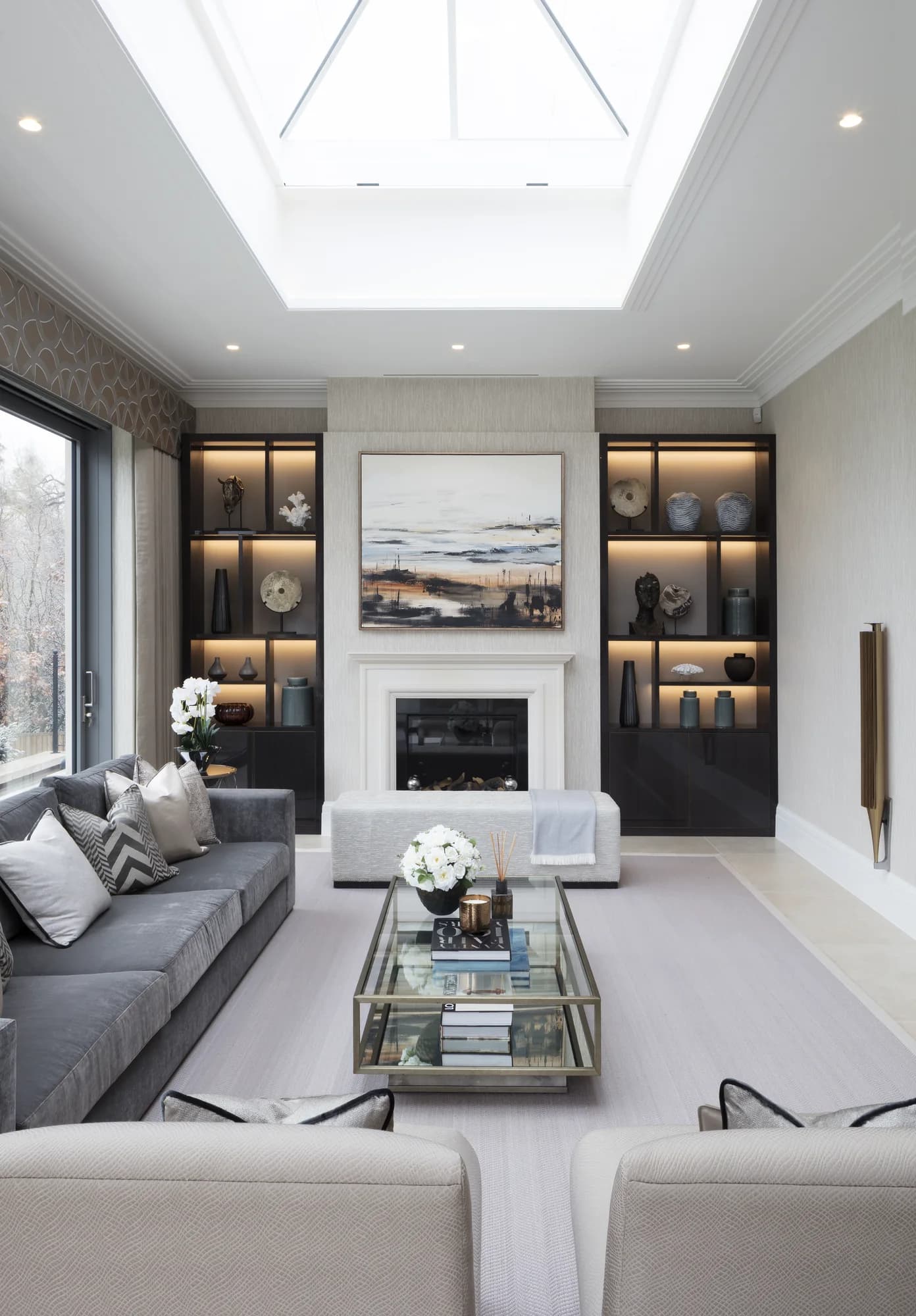 Full view of the illuminated alcove pair beside the fireplace in the rooflit living room