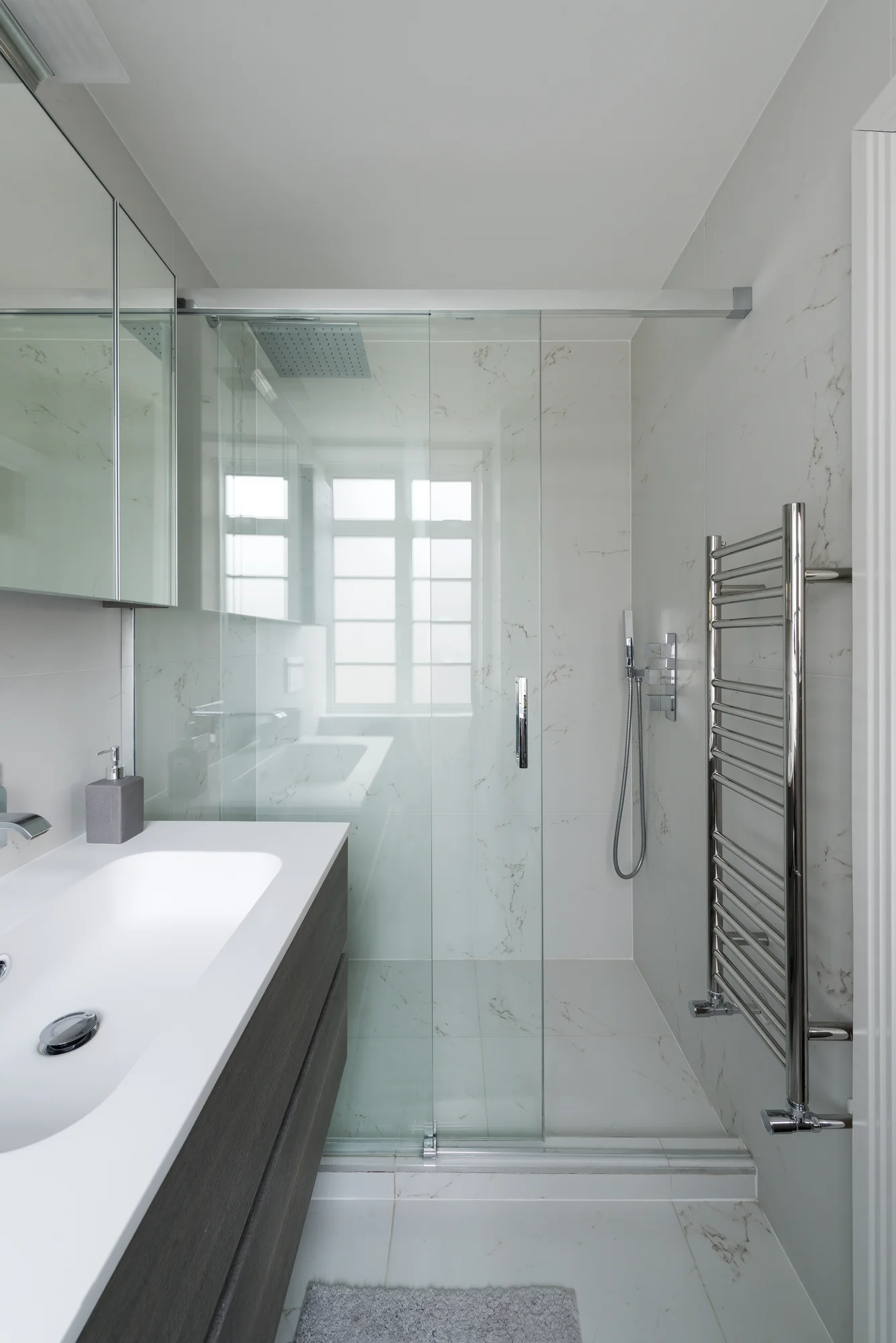 Floating bathroom vanity beside the glass shower enclosure