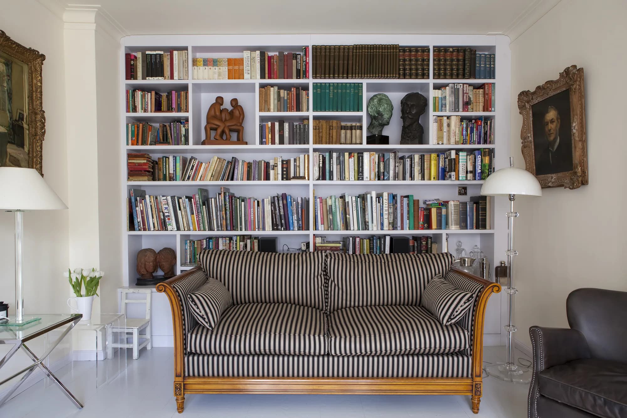 Full-wall white bookcase behind the sitting-room sofa